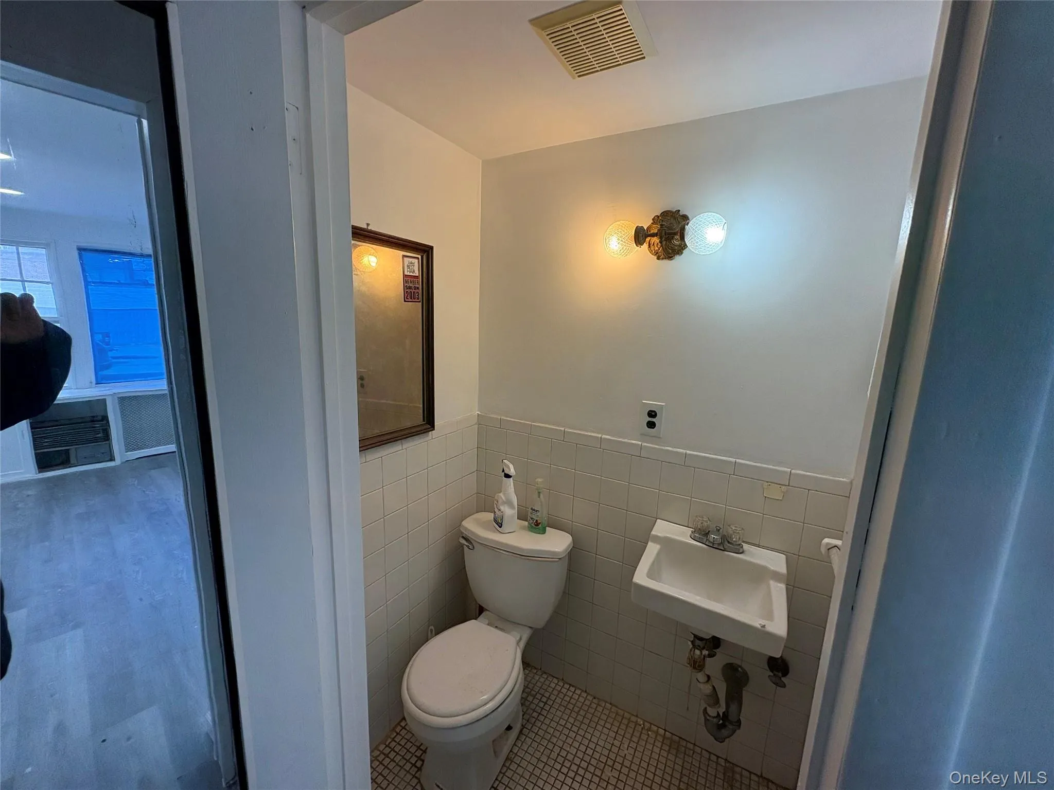 Bathroom with tile walls, a wainscoted wall, and tile patterned floors Bathroom with tile walls, a wainscoted wall, and tile patterned floors