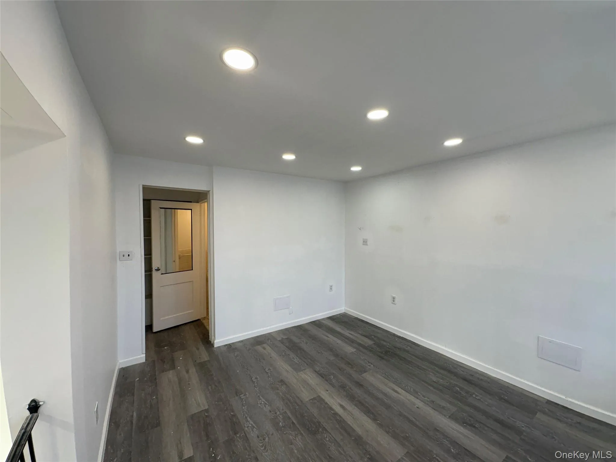 Empty room featuring dark wood-style flooring and recessed lighting Empty room featuring dark wood-style flooring and recessed lighting