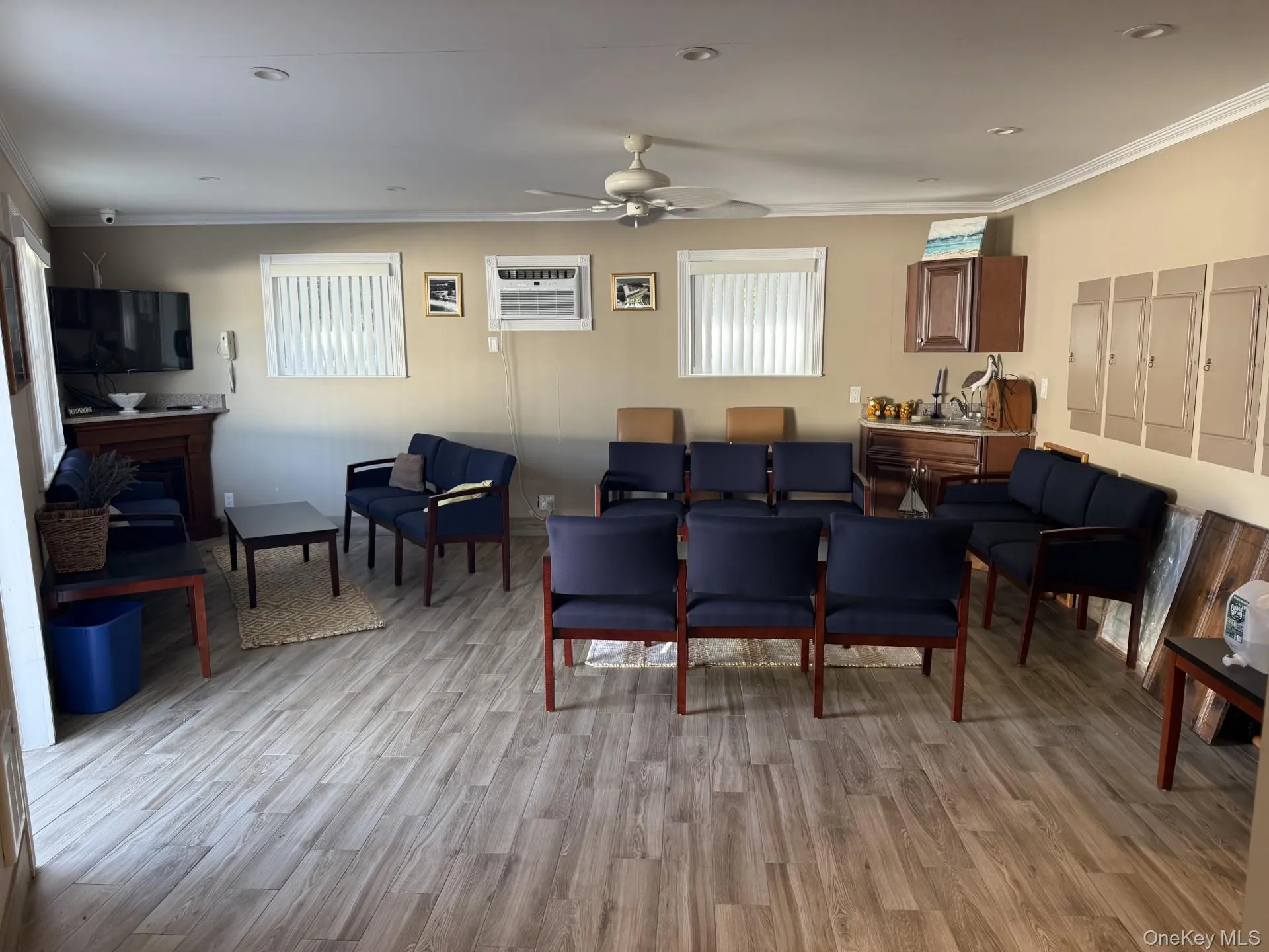 Living area with light wood-style floors, ornamental molding, ceiling fan, an AC wall unit, and recessed lighting Living area with light wood-style floors, ornamental molding, ceiling fan, an AC wall unit, and recessed lighting