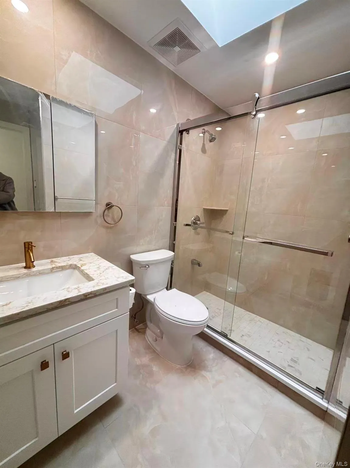 Full bath with a stall shower, vanity, and tile walls Full bath with a stall shower, vanity, and tile walls