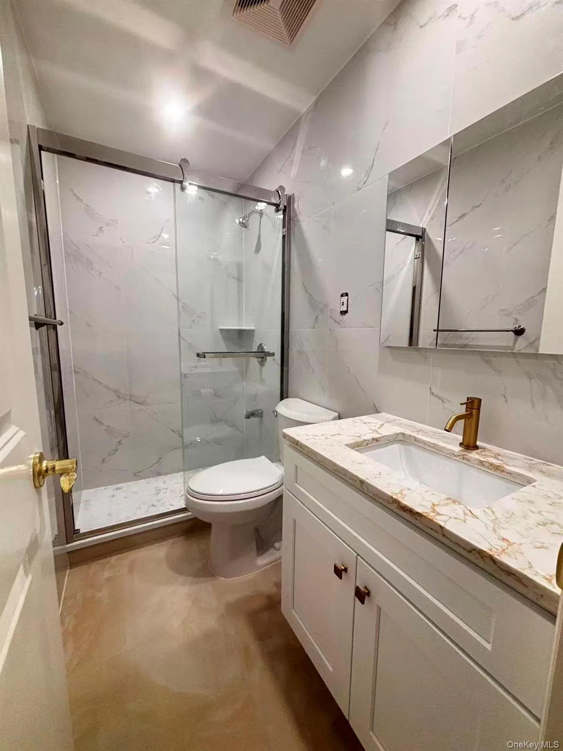 Bathroom with vanity, a marble finish shower, and tile walls Bathroom with vanity, a marble finish shower, and tile walls