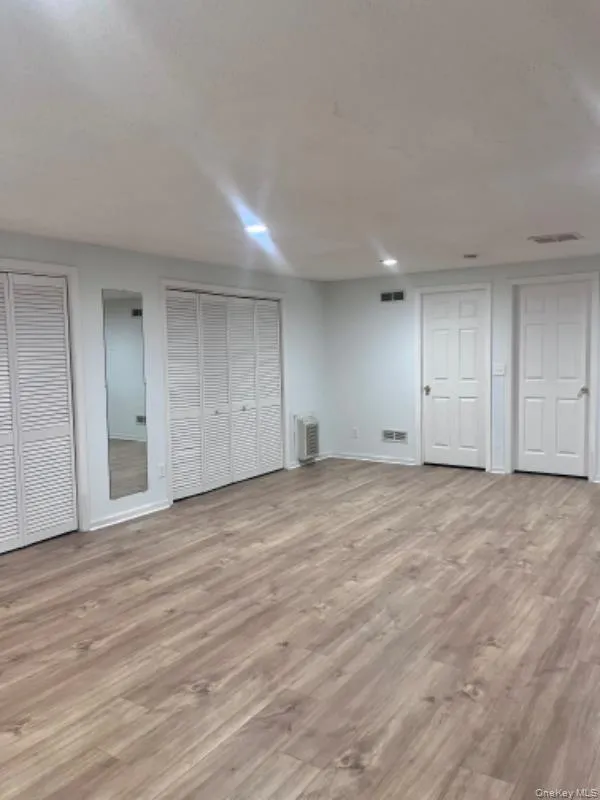 Unfurnished bedroom with multiple closets and light wood-style flooring Unfurnished bedroom with multiple closets and light wood-style flooring