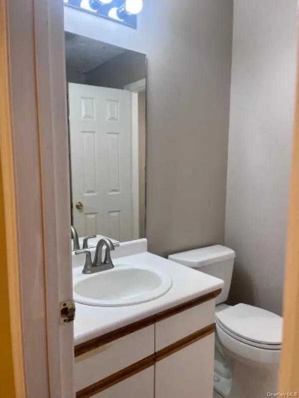 Half bathroom featuring vanity and toilet Half bathroom featuring vanity and toilet