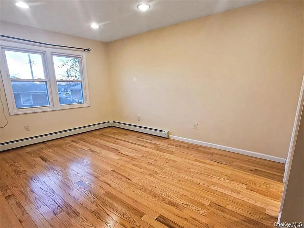 Spare room featuring light wood-type flooring, recessed lighting, and a baseboard heating unit Spare room featuring light wood-type flooring, recessed lighting, and a baseboard heating unit