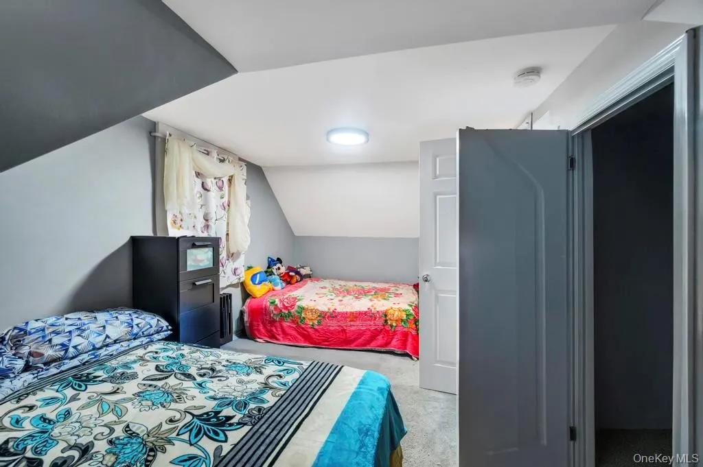 Bedroom with lofted ceiling and light carpet Bedroom with lofted ceiling and light carpet