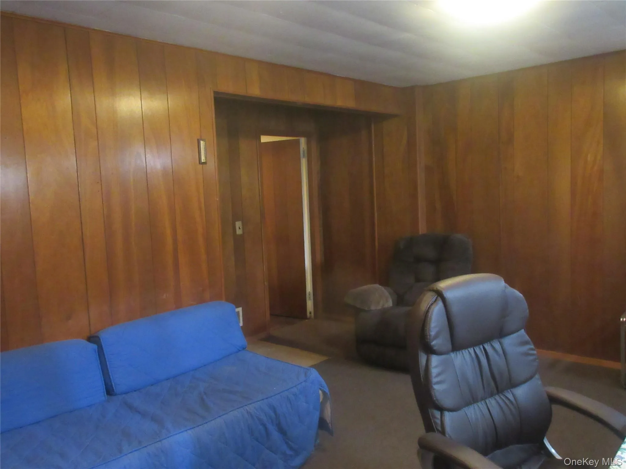 Bedroom featuring wooden walls and carpet flooring Bedroom featuring wooden walls and carpet flooring