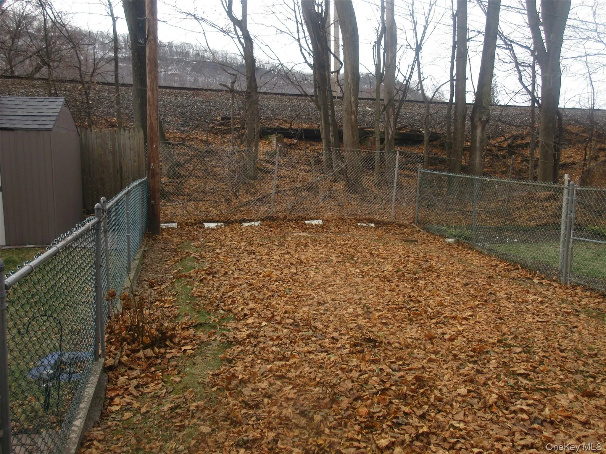 Fenced backyard with a storage unit Fenced backyard with a storage unit
