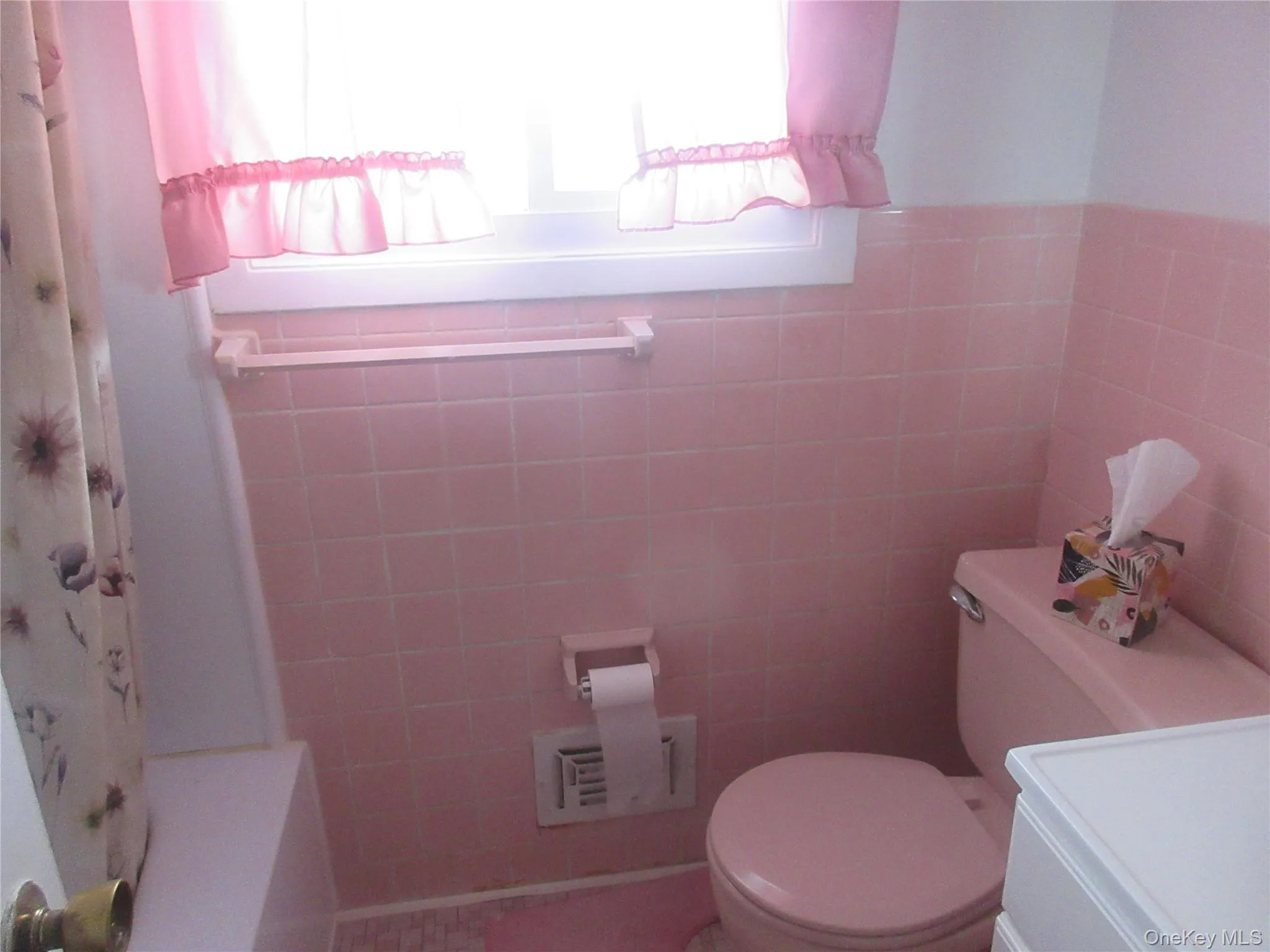 Bathroom featuring tile walls, wainscoting, and shower / tub combo Bathroom featuring tile walls, wainscoting, and shower / tub combo