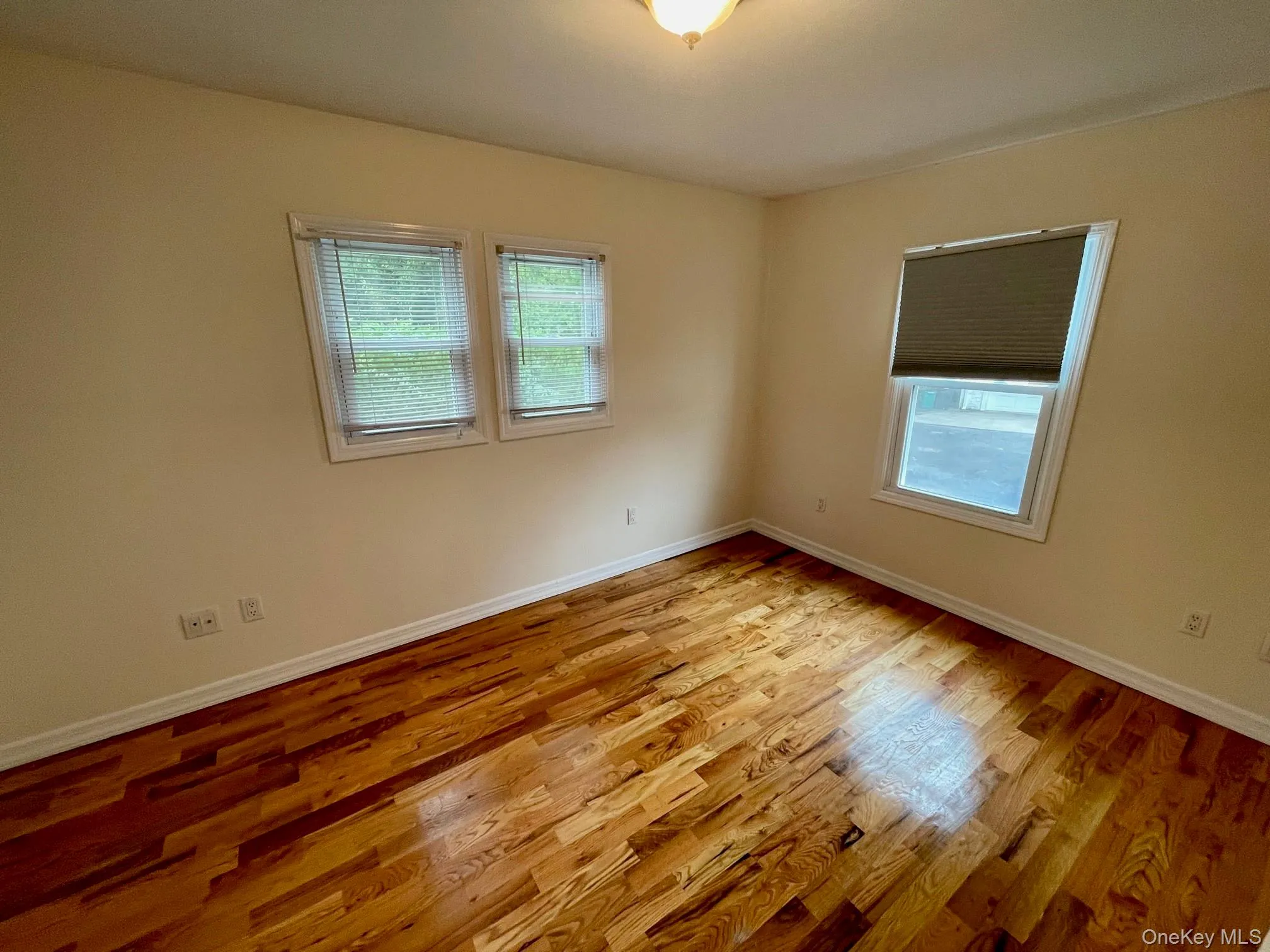 Empty room with light wood-style floors and baseboards Empty room with light wood-style floors and baseboards