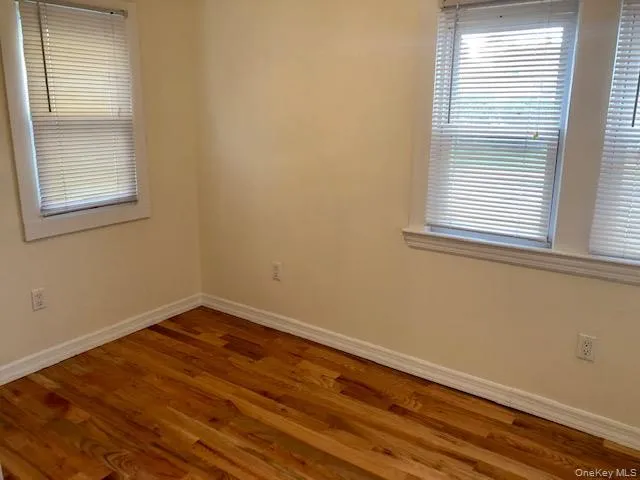 Unfurnished room featuring wood finished floors and baseboards Unfurnished room featuring wood finished floors and baseboards