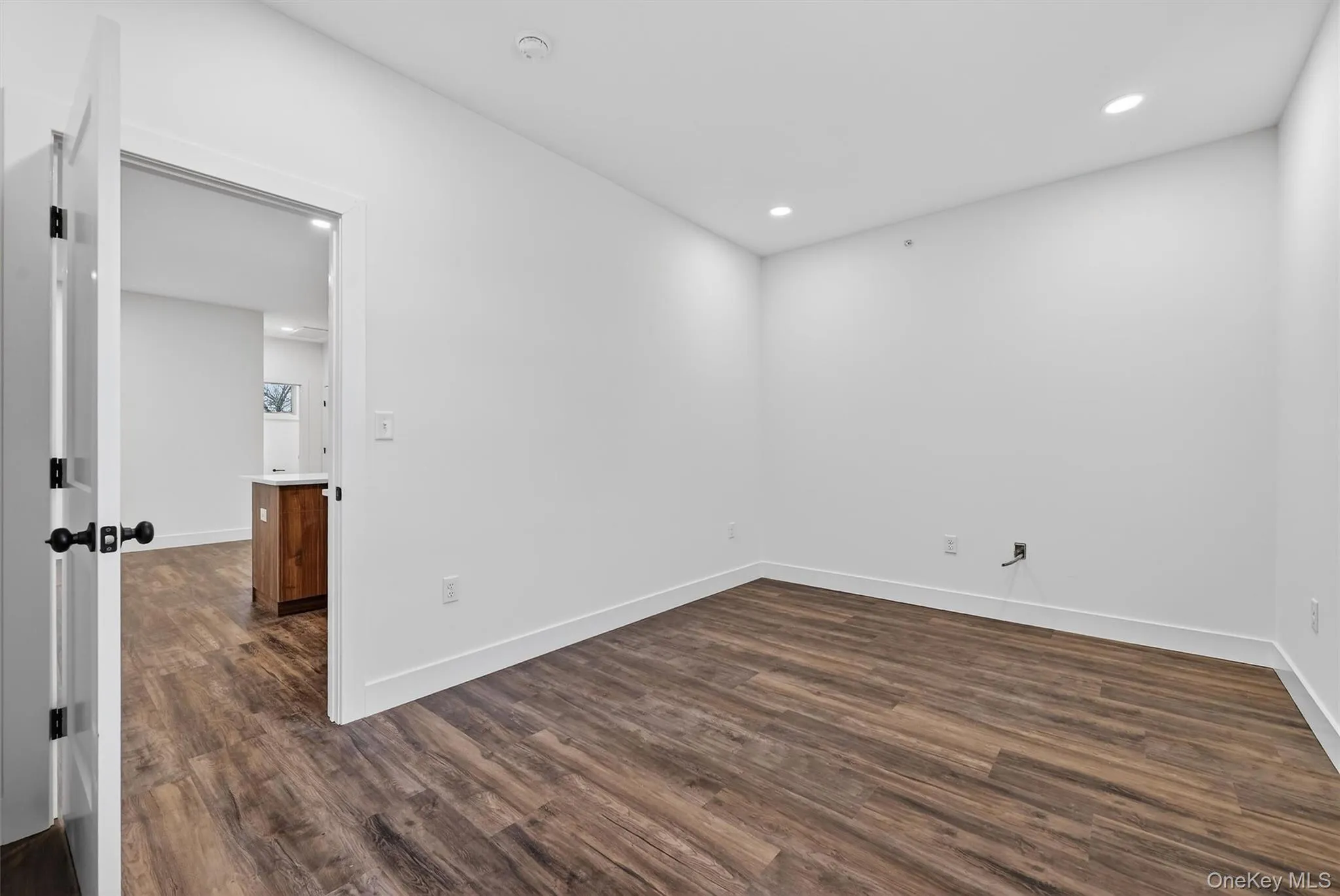 Empty room featuring dark wood finished floors and recessed lighting Empty room featuring dark wood finished floors and recessed lighting