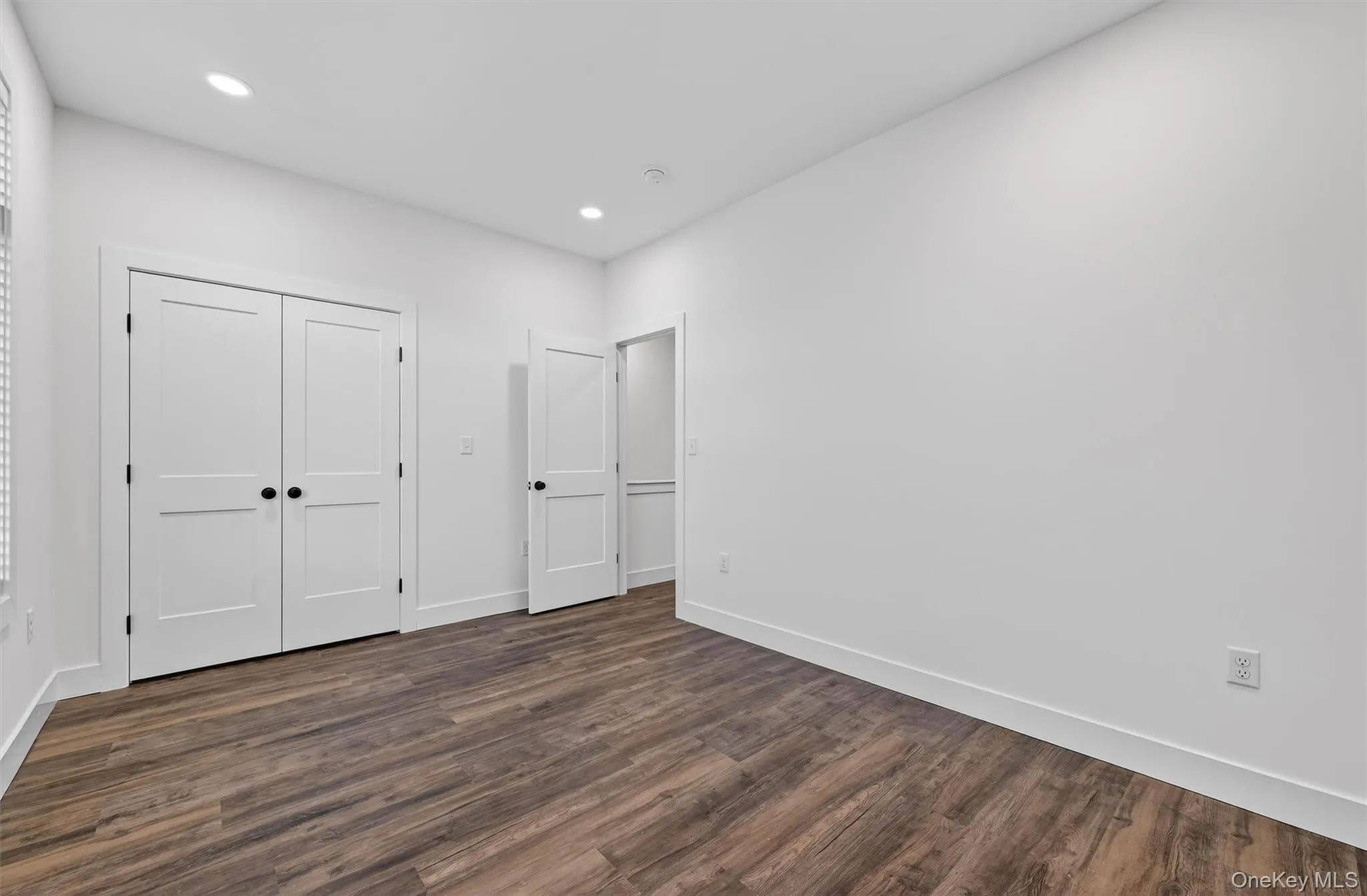 Unfurnished bedroom with dark wood finished floors, a closet, and recessed lighting Unfurnished bedroom with dark wood finished floors, a closet, and recessed lighting