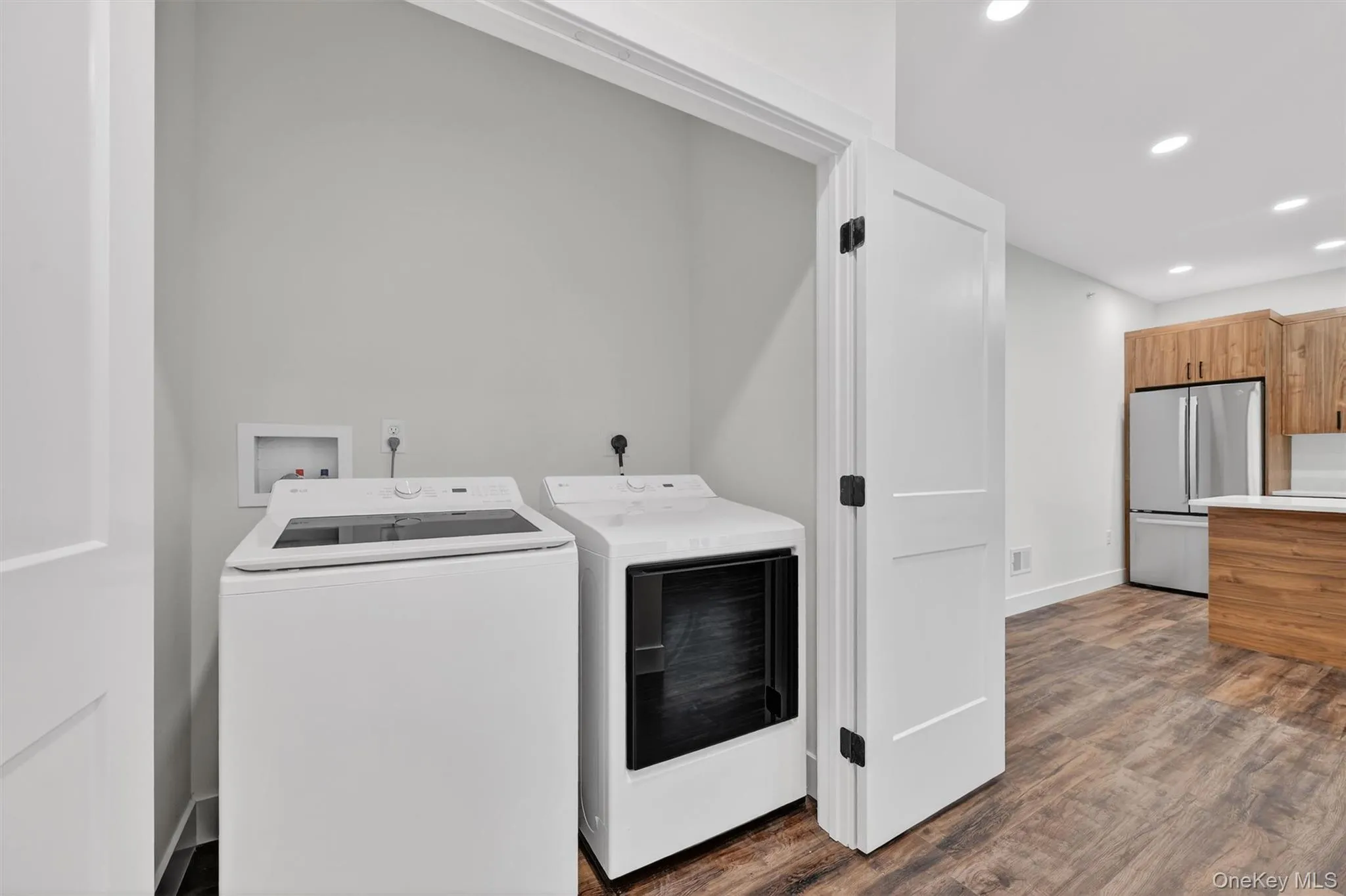 Laundry room with recessed lighting, dark wood-type flooring, and independent washer and dryer Laundry room with recessed lighting, dark wood-type flooring, and independent washer and dryer