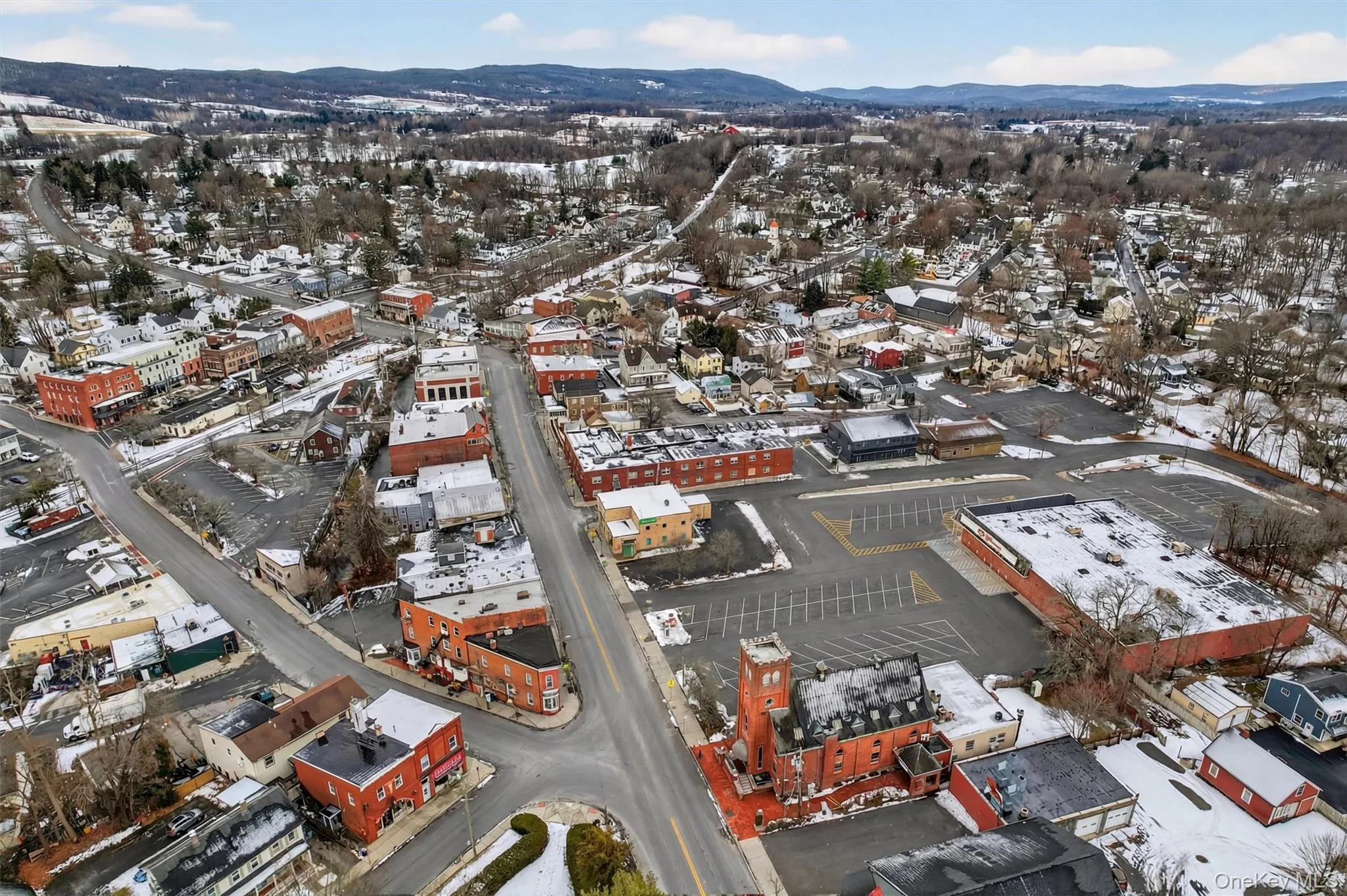 Snowy aerial view featuring a mountain view Snowy aerial view featuring a mountain view