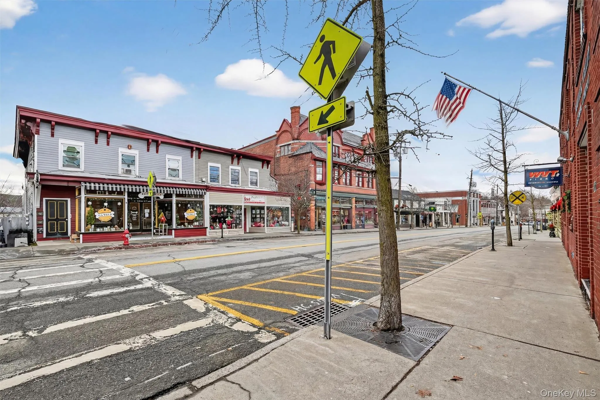 View of asphalt road featuring sidewalks, curbs, traffic signs, and street lighting View of asphalt road featuring sidewalks, curbs, traffic signs, and street lighting
