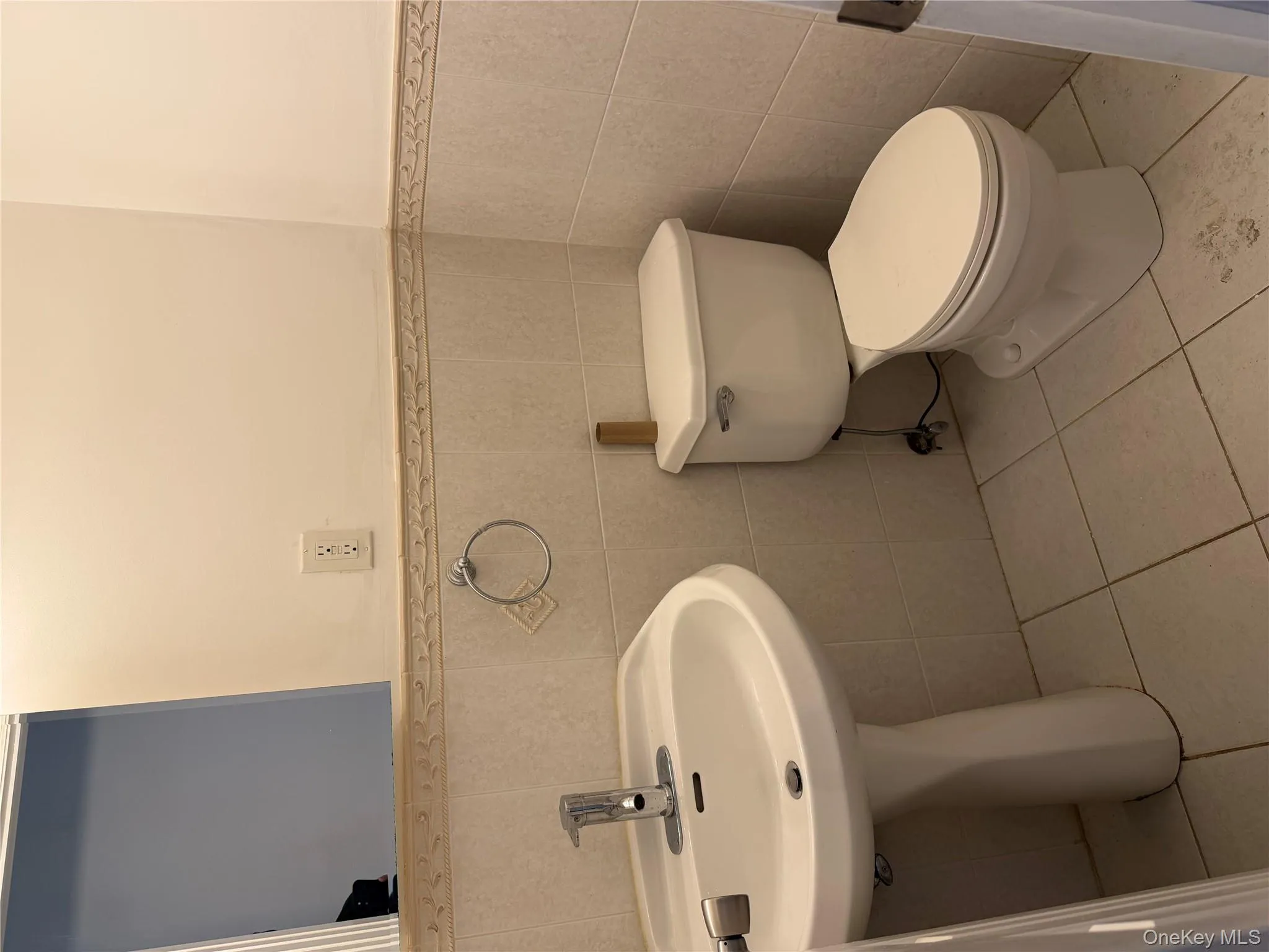 Half bathroom with wainscoting, light tile patterned floors, and tile walls Half bathroom with wainscoting, light tile patterned floors, and tile walls