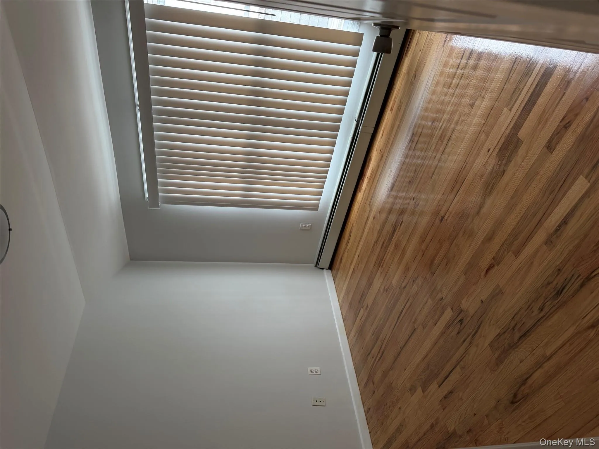 Unfurnished room featuring a baseboard heating unit and wood finished floors Unfurnished room featuring a baseboard heating unit and wood finished floors