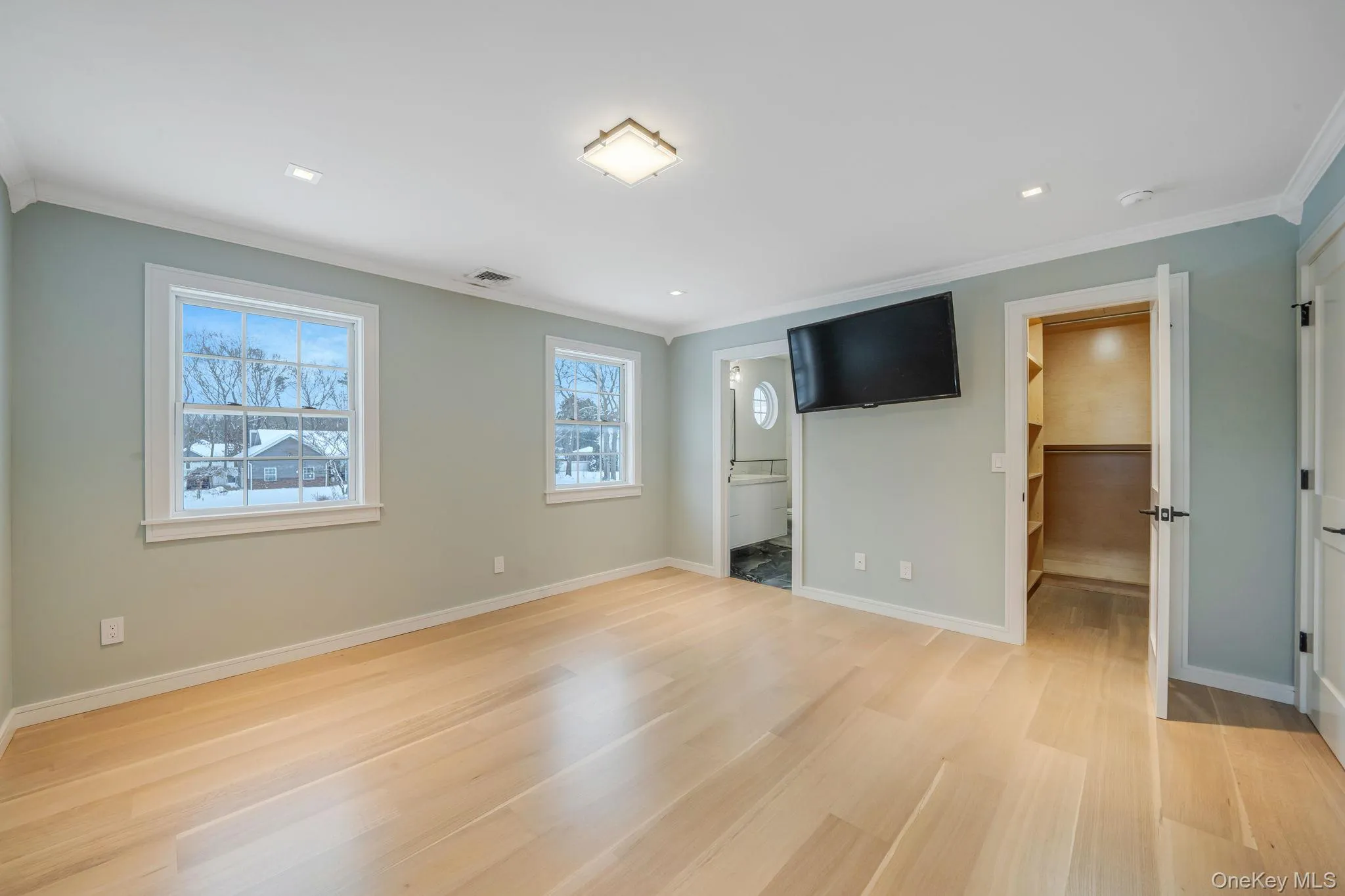 Unfurnished bedroom featuring a walk in closet, light wood-style flooring, ornamental molding, ensuite bath, and recessed lighting Unfurnished bedroom featuring a walk in closet, light wood-style flooring, ornamental molding, ensuite bath, and recessed lighting