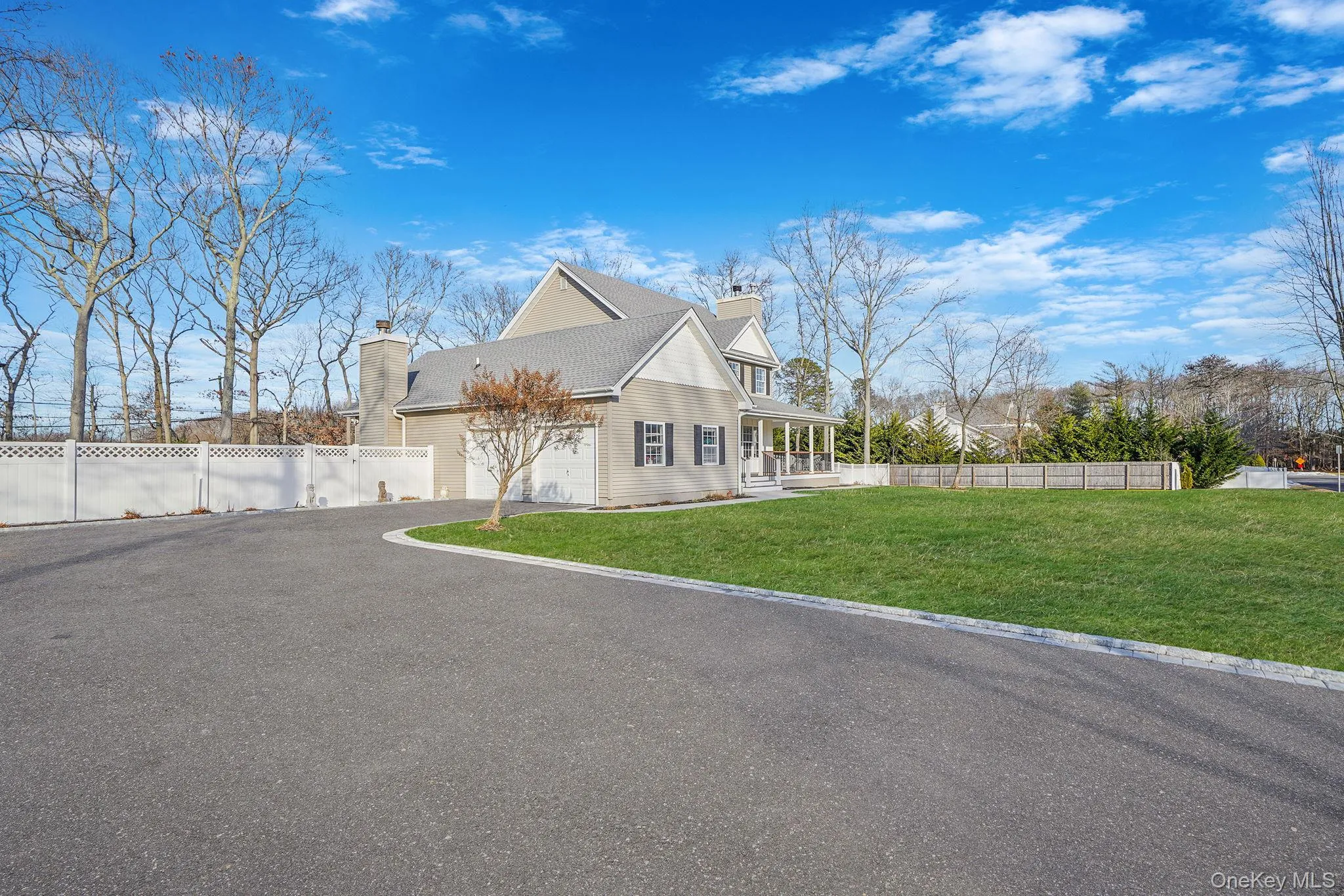 View of side of home featuring asphalt driveway, a chimney, a porch, and an attached garage View of side of home featuring asphalt driveway, a chimney, a porch, and an attached garage