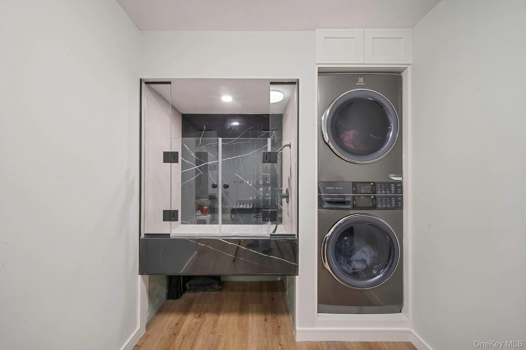 Laundry room with stacked washer / dryer and doggie shower Laundry room with stacked washer / dryer and doggie shower