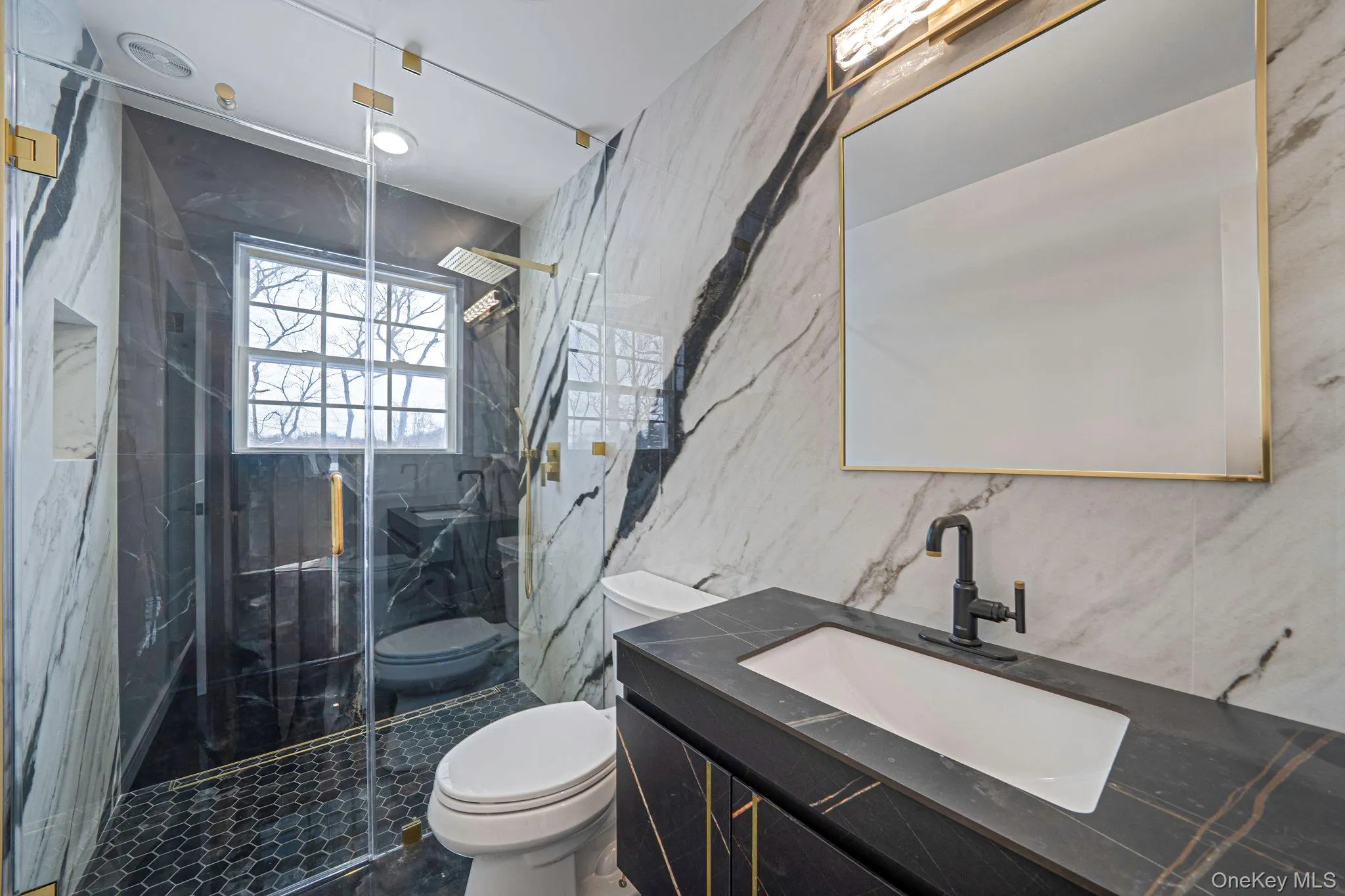Full bath with vanity, a marble finish shower, stone wall, and tile walls Full bath with vanity, a marble finish shower, stone wall, and tile walls