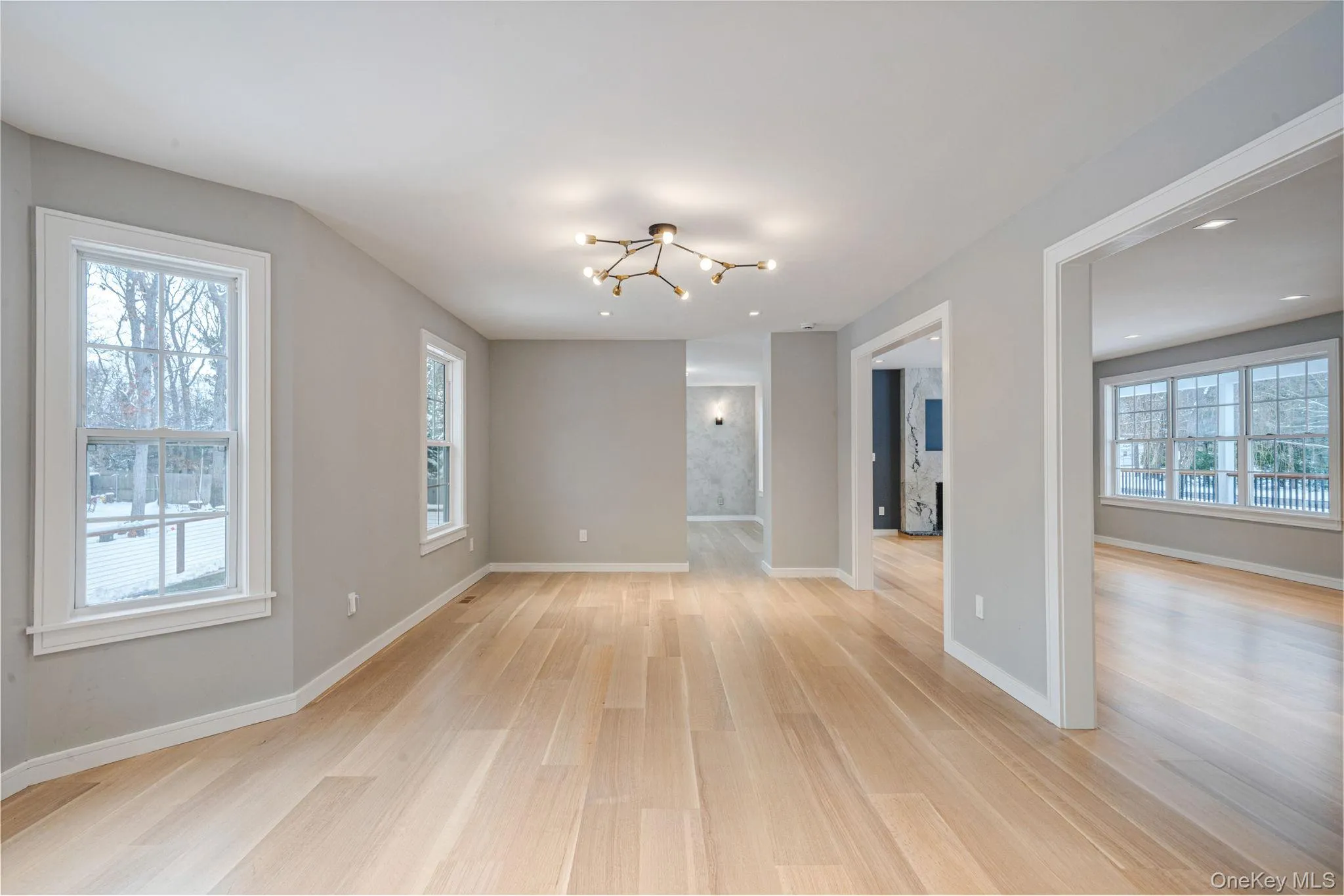 Empty room featuring light wood-style floors and a chandelier Empty room featuring light wood-style floors and a chandelier
