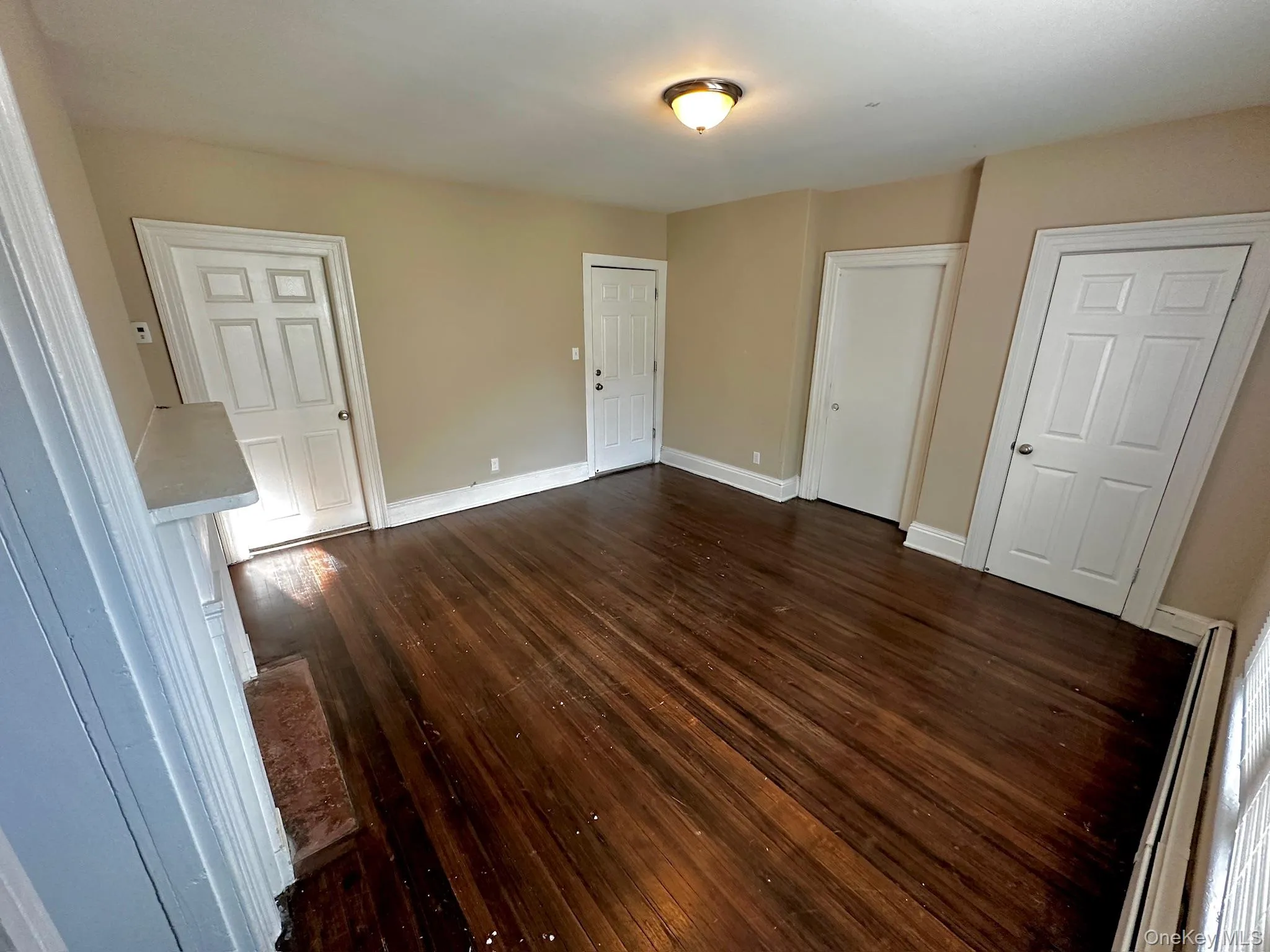 Unfurnished bedroom featuring dark wood-style flooring and baseboards Unfurnished bedroom featuring dark wood-style flooring and baseboards