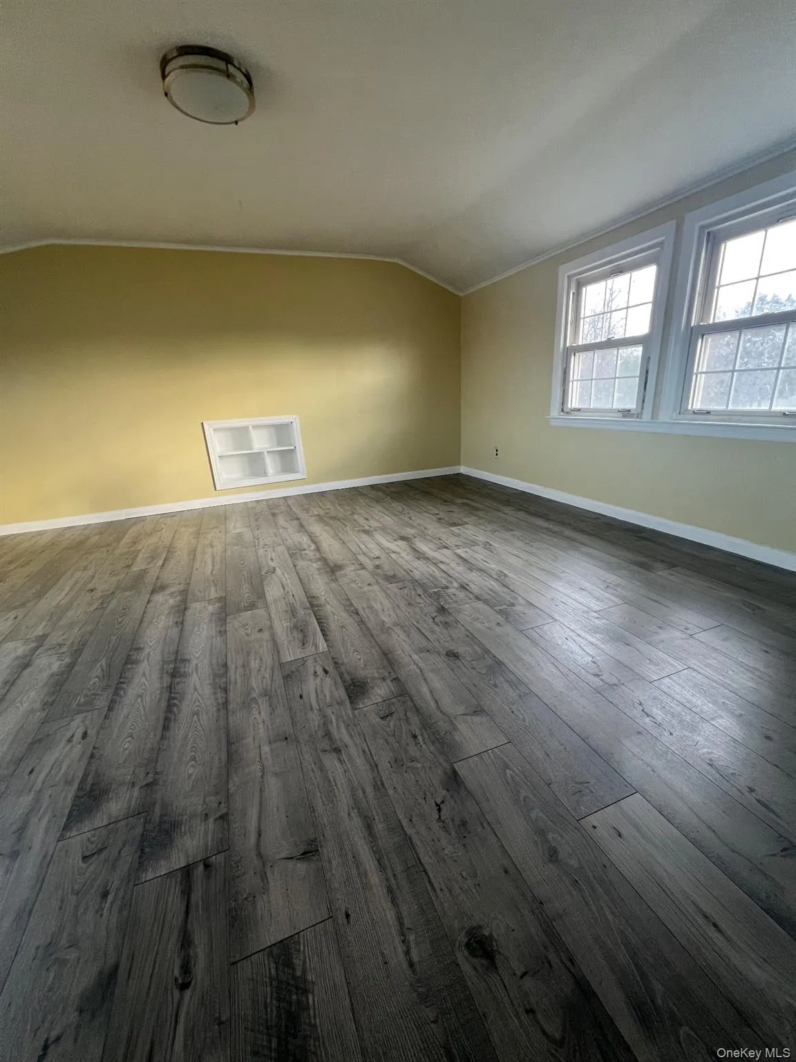 Additional living space with vaulted ceiling and dark wood-style flooring Additional living space with vaulted ceiling and dark wood-style flooring