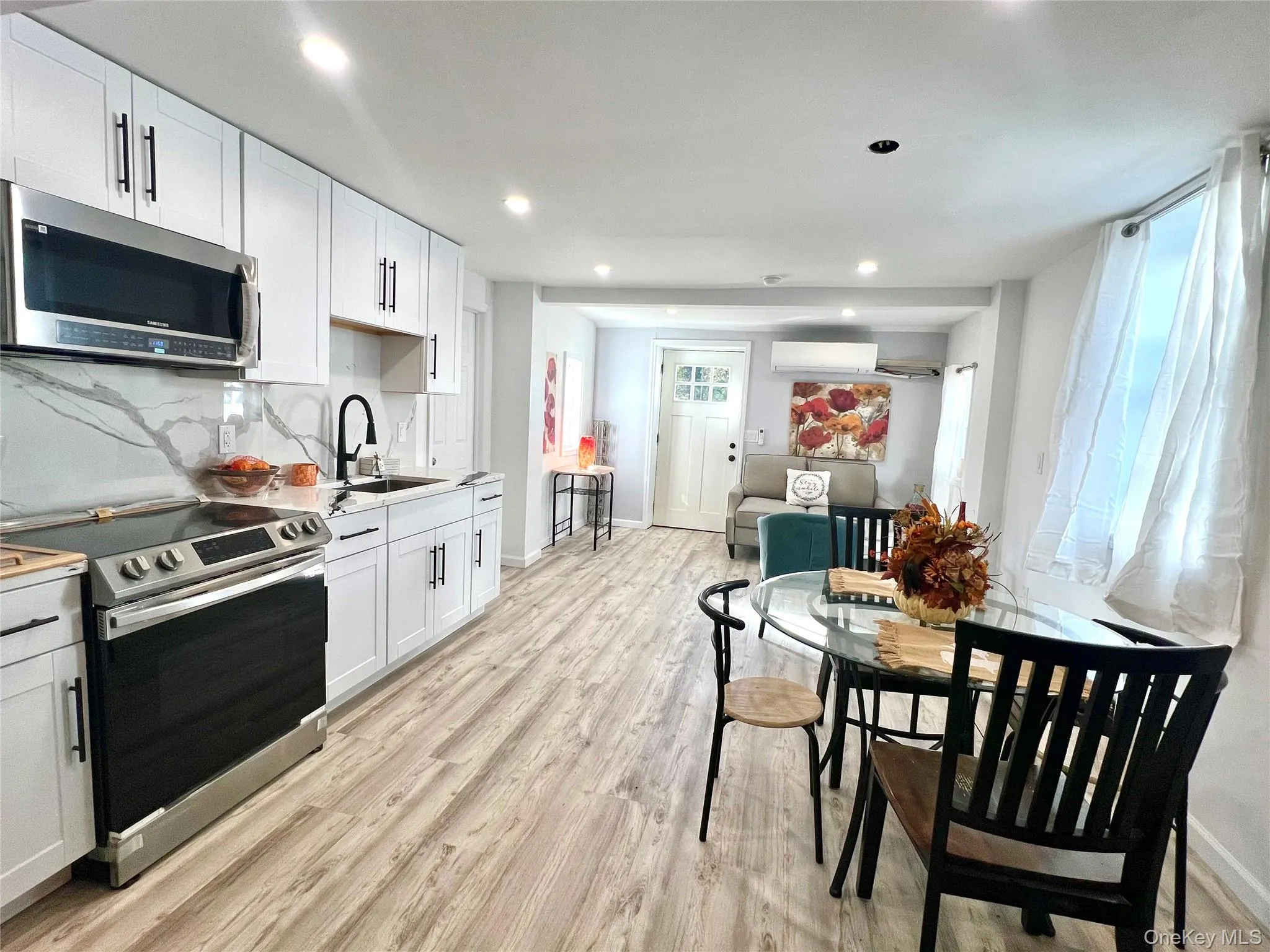 Kitchen featuring appliances with stainless steel finishes, light wood-type flooring, white cabinetry, and recessed lighting Kitchen featuring appliances with stainless steel finishes, light wood-type flooring, white cabinetry, and recessed lighting