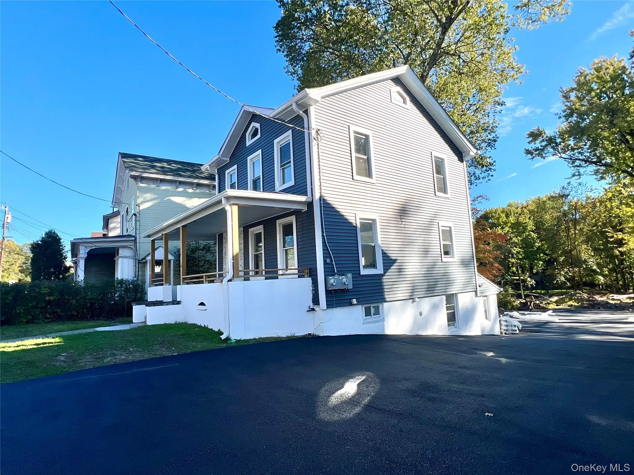 View of side of home with covered porch and a yard View of side of home with covered porch and a yard