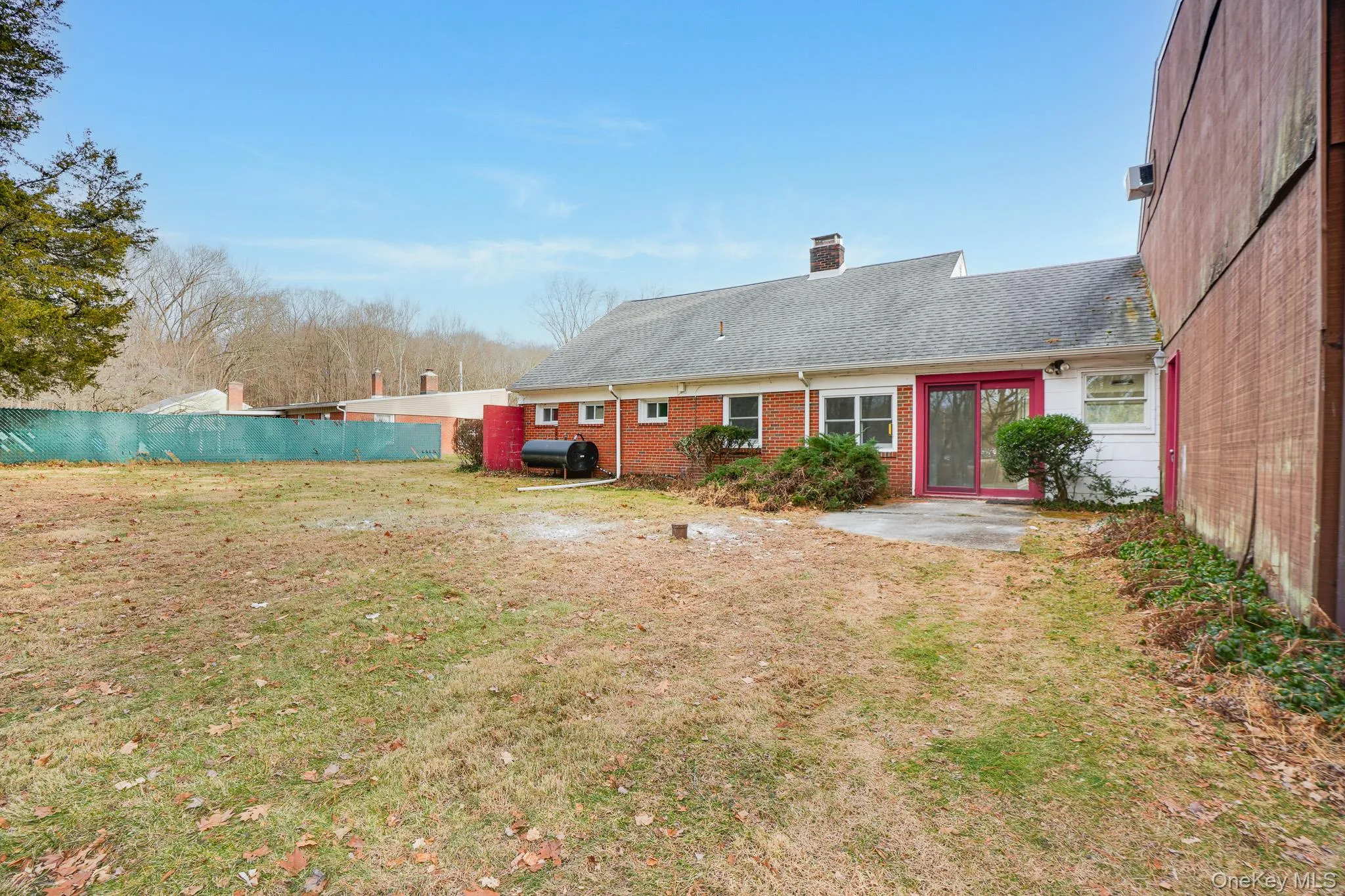 Back of property with a patio area, heating fuel, roof with shingles, brick siding, and a chimney Back of property with a patio area, heating fuel, roof with shingles, brick siding, and a chimney