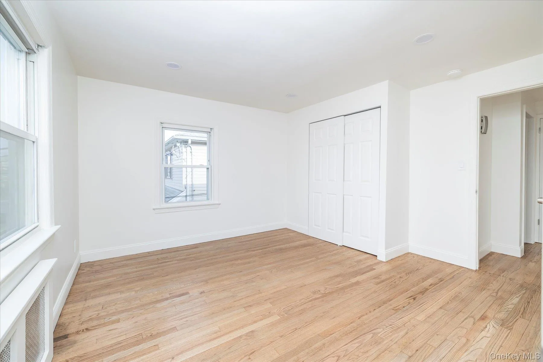 Bedroom #2 with 2 closets, light wood flooring, radiator and plenty of natural light Bedroom #2 with 2 closets, light wood flooring, radiator and plenty of natural light