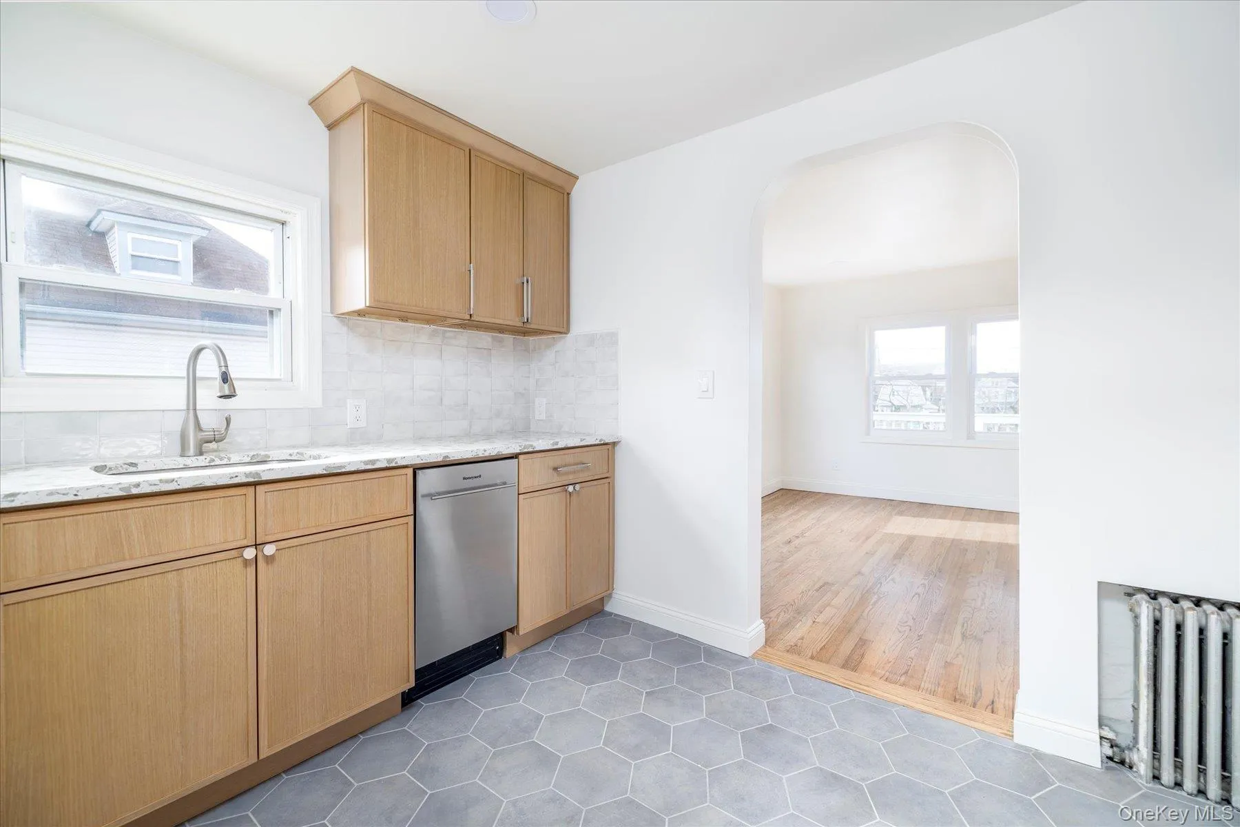 New kitchen featuring white oak cabinets, quartz countertops,ceramic backsplash, stainless steel appliances, & grey tile floor New kitchen featuring white oak cabinets, quartz countertops,ceramic backsplash, stainless steel appliances, & grey tile floor