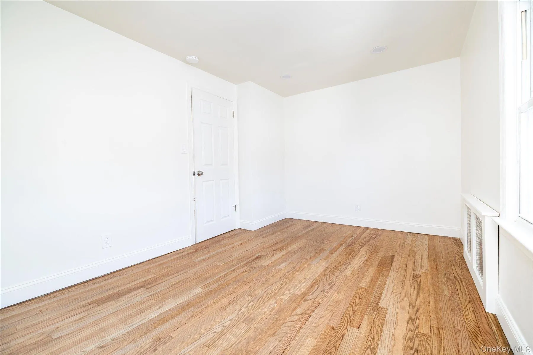 Bedroom #3 featuring radiator heating unit, light wood flooring, and a closet Bedroom #3 featuring radiator heating unit, light wood flooring, and a closet