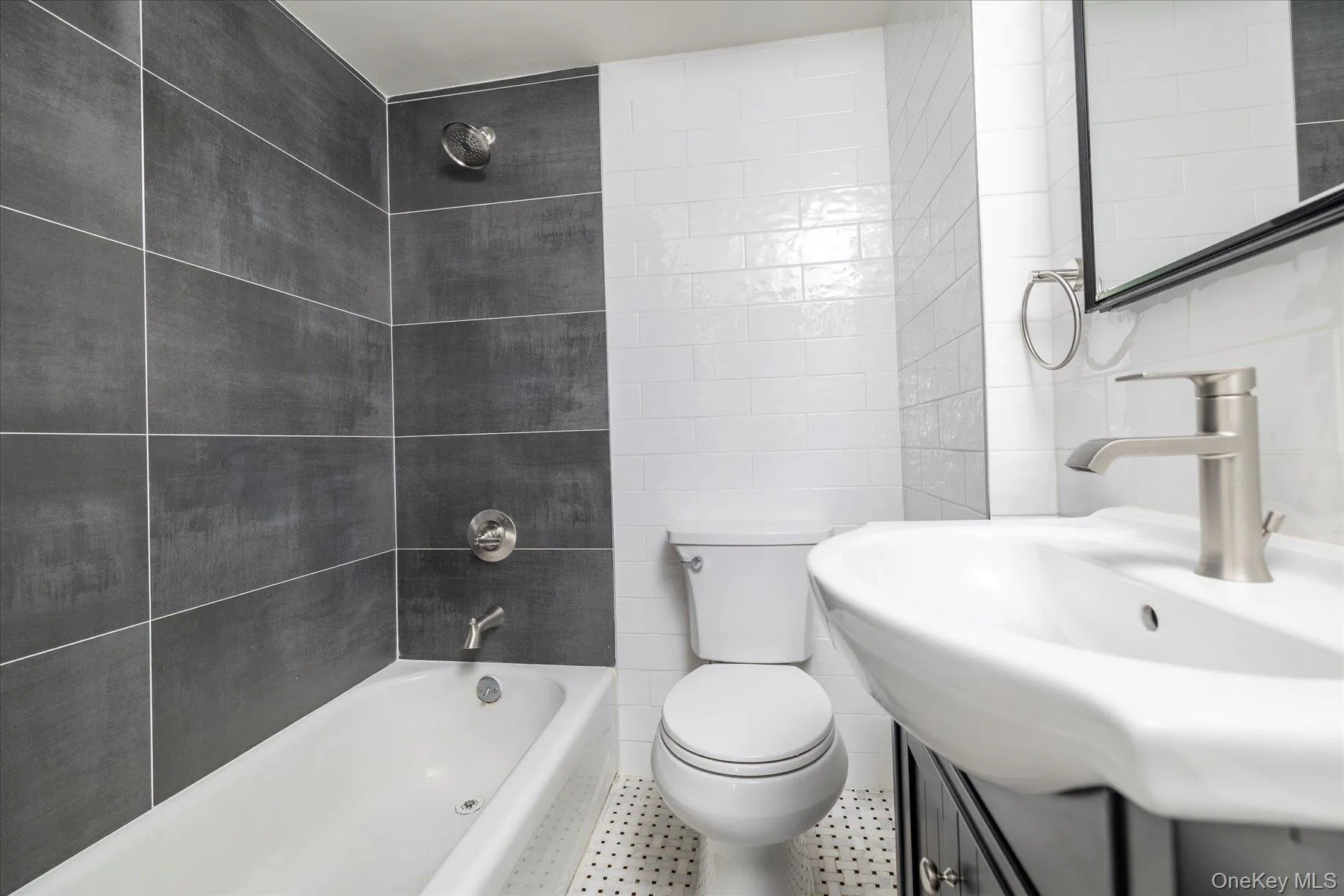 Bathroom featuring tile walls, vanity, recessed medicine cabinet, washtub / shower combination & marble flooring Bathroom featuring tile walls, vanity, recessed medicine cabinet, washtub / shower combination & marble flooring