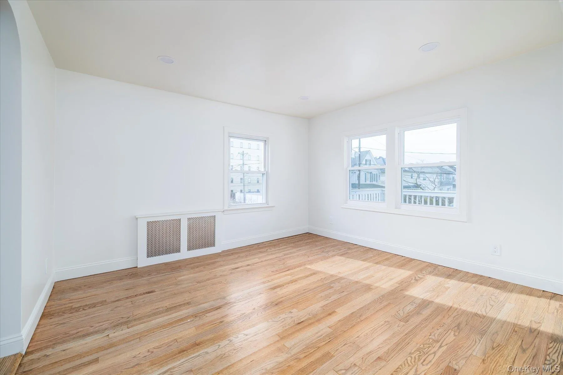 Living room featuring light wood flooring, plenty of natural light, arched entryway Living room featuring light wood flooring, plenty of natural light, arched entryway