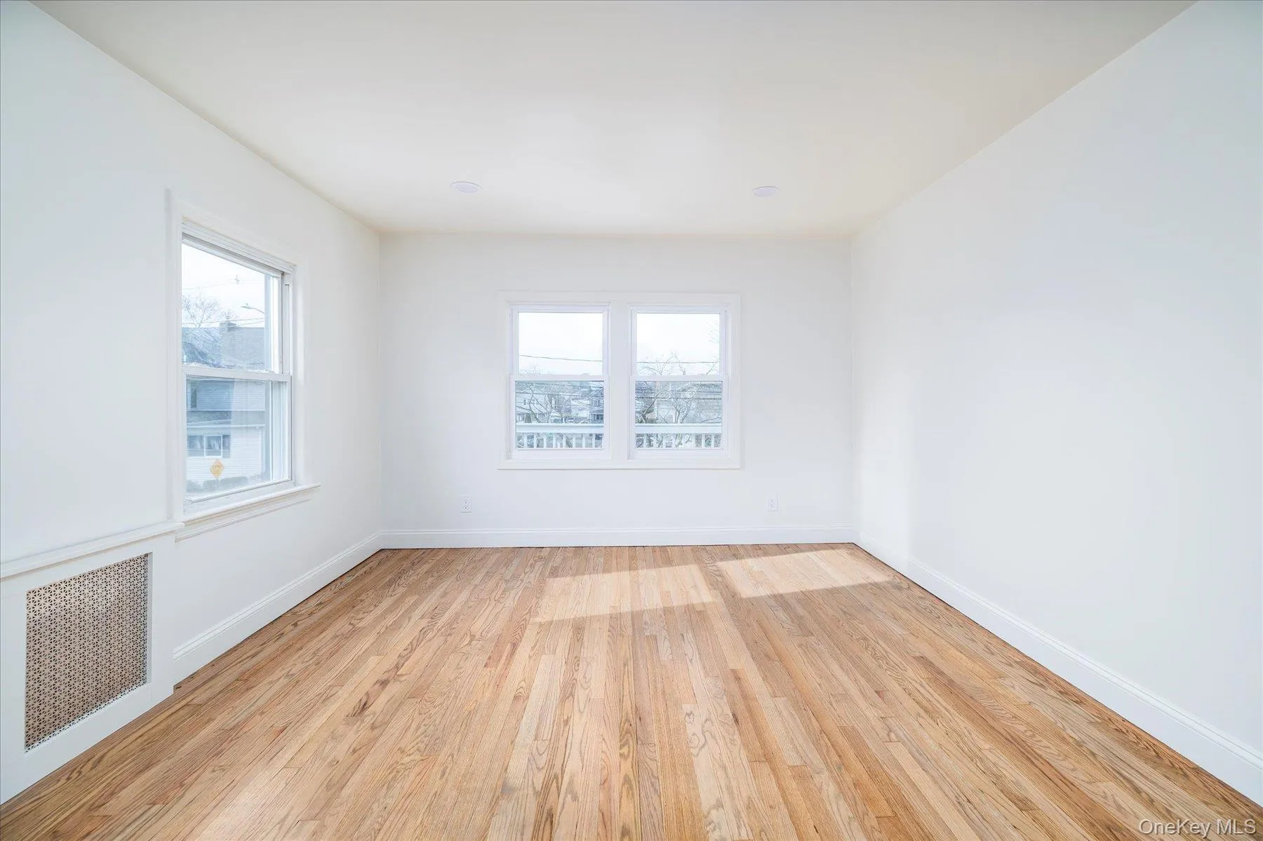 Living room featuring light wood flooring, plenty of natural light, arched entryway Living room featuring light wood flooring, plenty of natural light, arched entryway