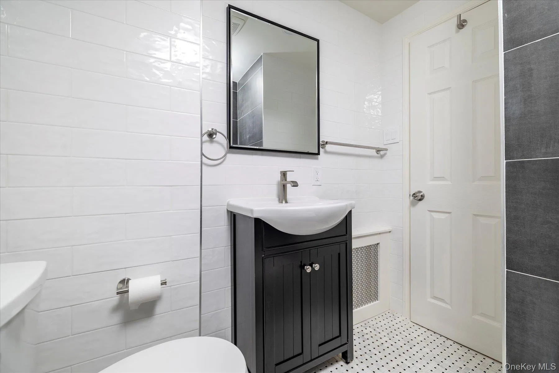 Bathroom featuring tile walls, vanity, recessed medicine cabinet, washtub / shower combination & marble flooring Bathroom featuring tile walls, vanity, recessed medicine cabinet, washtub / shower combination & marble flooring