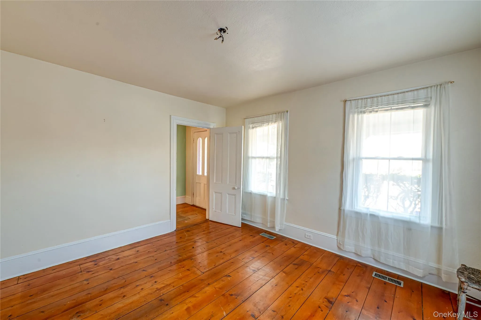 Spare room with baseboards and hardwood / wood-style flooring Spare room with baseboards and hardwood / wood-style flooring