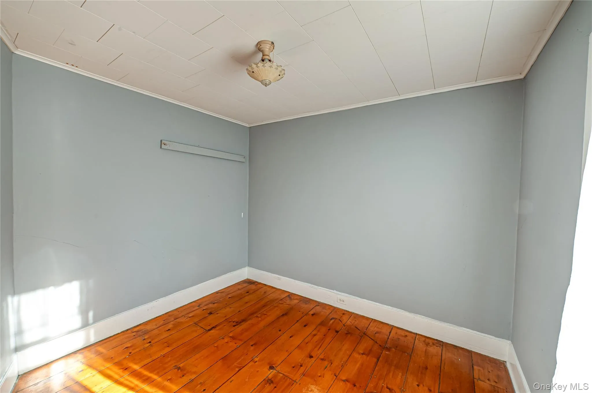 Spare room with hardwood / wood-style floors and crown molding Spare room with hardwood / wood-style floors and crown molding