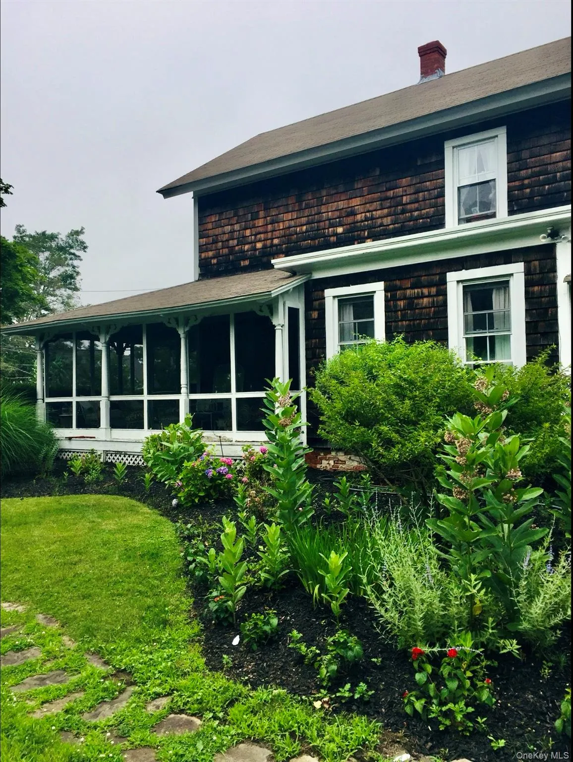 Back of property with a sunroom and a chimney Back of property with a sunroom and a chimney