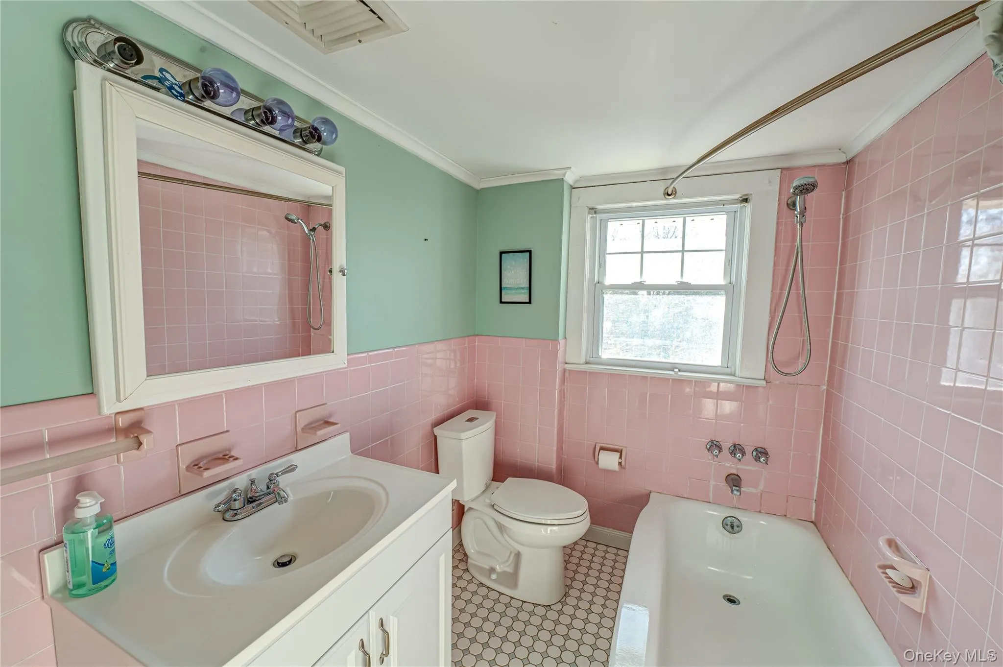 Full bath with vanity, bathtub / shower combination, tile walls, wainscoting, and ornamental molding Full bath with vanity, bathtub / shower combination, tile walls, wainscoting, and ornamental molding