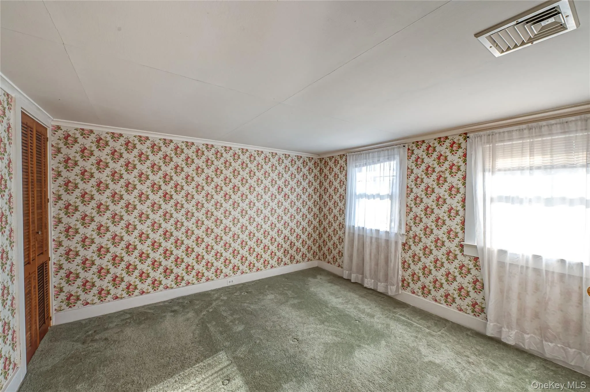 Carpeted spare room with wallpapered walls and crown molding Carpeted spare room with wallpapered walls and crown molding