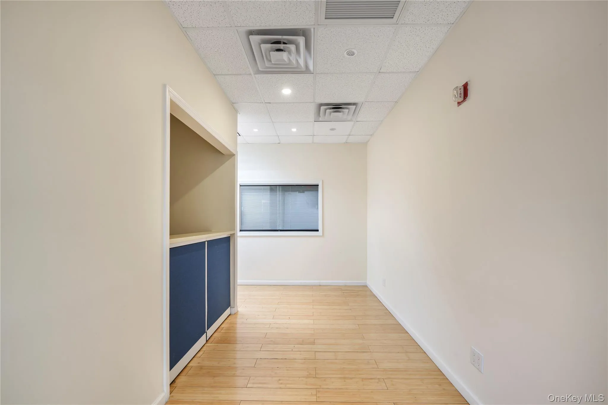 Corridor featuring a drop ceiling, light wood-style floors, and recessed lighting Corridor featuring a drop ceiling, light wood-style floors, and recessed lighting