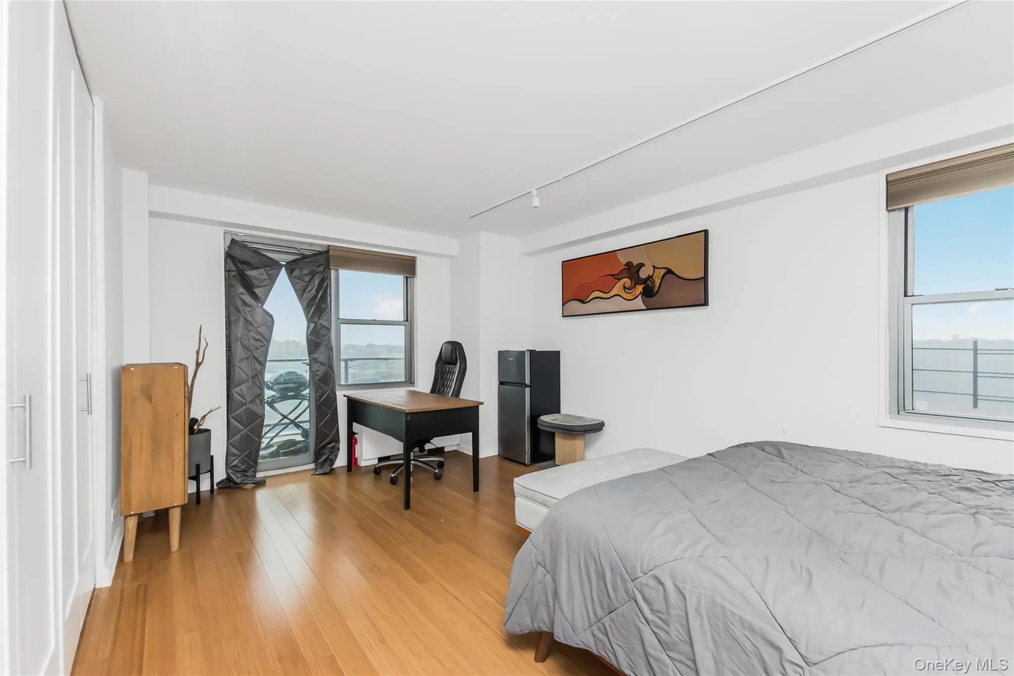 Bedroom featuring freestanding refrigerator and light wood-type flooring Bedroom featuring freestanding refrigerator and light wood-type flooring