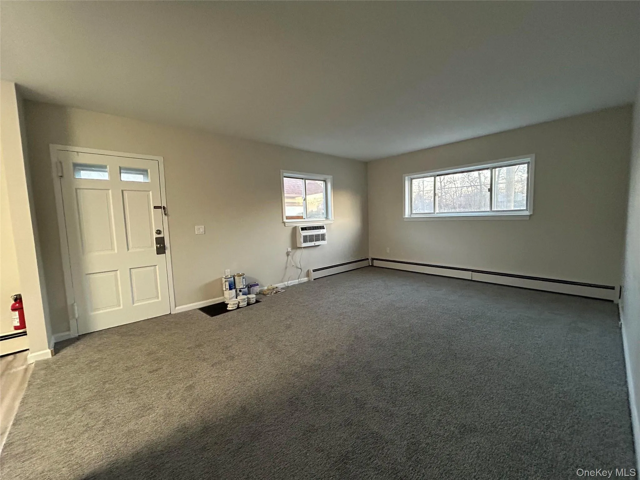 Carpeted empty room featuring baseboards and a baseboard heating unit Carpeted empty room featuring baseboards and a baseboard heating unit