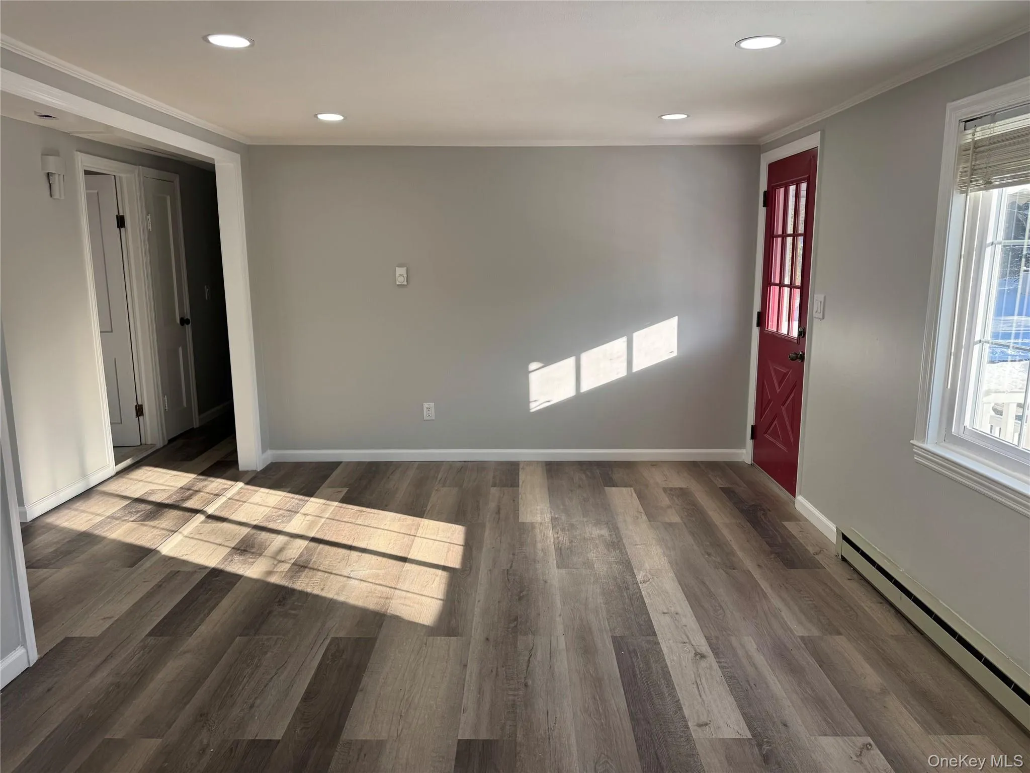 Entryway featuring a baseboard radiator, dark wood finished floors, recessed lighting, and crown molding Entryway featuring a baseboard radiator, dark wood finished floors, recessed lighting, and crown molding