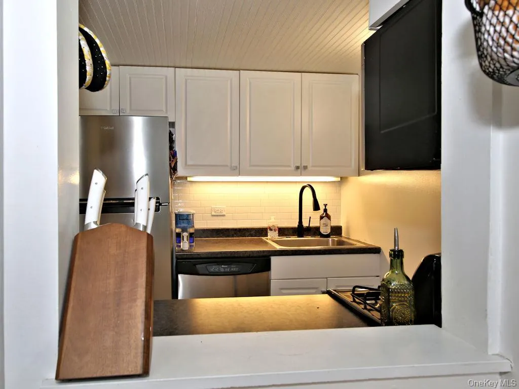Kitchen featuring white cabinetry, appliances with stainless steel finishes, and tasteful backsplash Kitchen featuring white cabinetry, appliances with stainless steel finishes, and tasteful backsplash