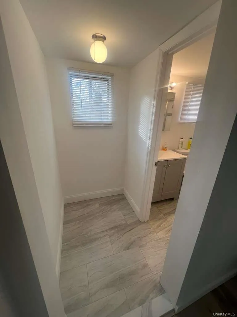 Bathroom featuring vanity and light marble finish floors Bathroom featuring vanity and light marble finish floors