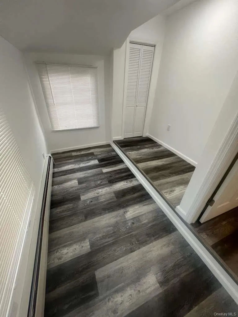 Unfurnished bedroom featuring a closet and dark wood-style floors Unfurnished bedroom featuring a closet and dark wood-style floors